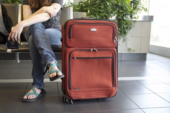 kobieta siedząca z walizką na lotnisku