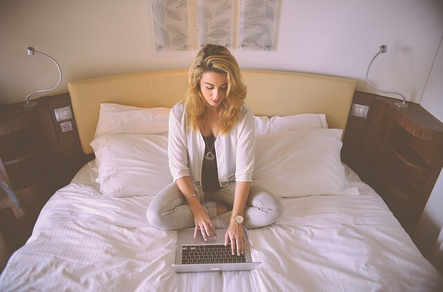 dziewczyna w łóżku pisze na laptopie