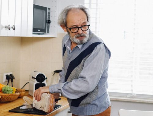 Dziadek w swetrze w kuchni